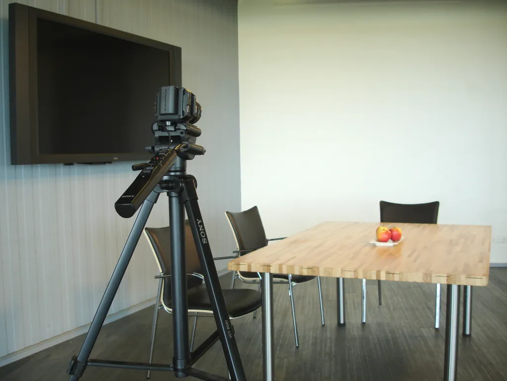 Eigen CORPUS/GEOCAST-opnamesetting met tafel, stoelen, scherm en camera in Oegstgeest