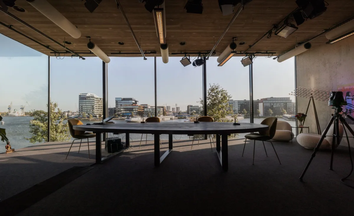 Opnameruimte van Crowdale met tafel, camera’s en grote ramen aan het IJ