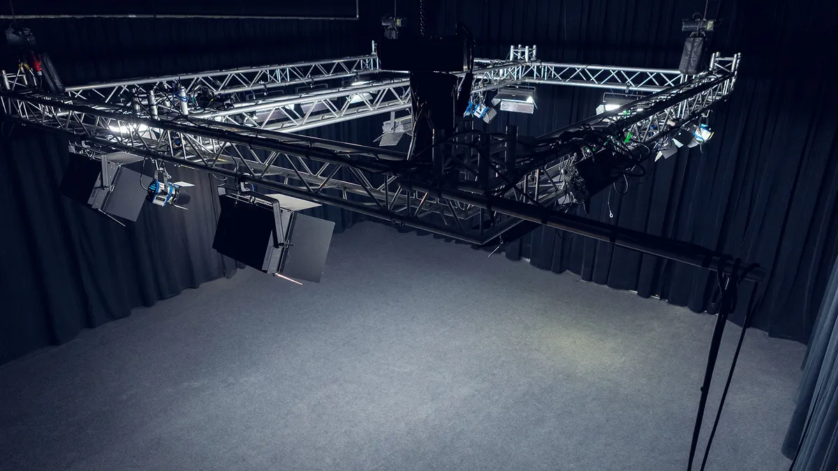 Lege opnamestudio van Het Nieuwe Kader in Arnhem met lichttruss en zwarte gordijnen
