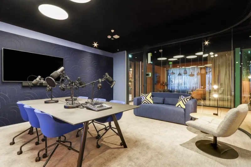 Eigen podcaststudio van HNK Amsterdam met tafel, microfoons en zitmeubilair