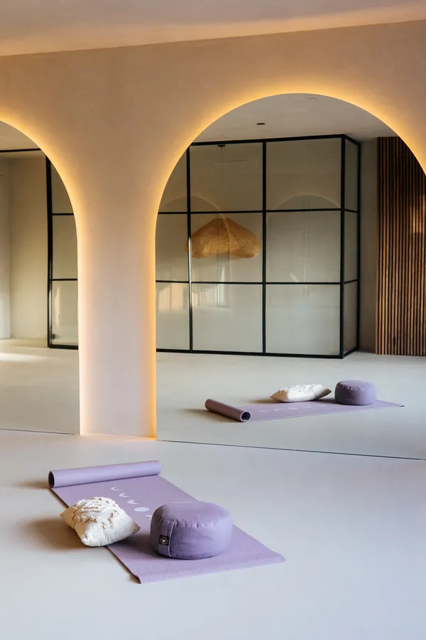 Bovenruimte van House of Being met bogen, spiegelwand, glazen scheidingswand en yogamat