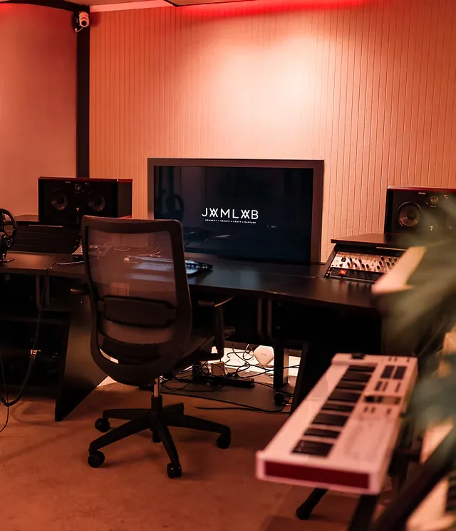 Ruby-muziekstudio met scherm, studiomonitors, werkplek en keyboard