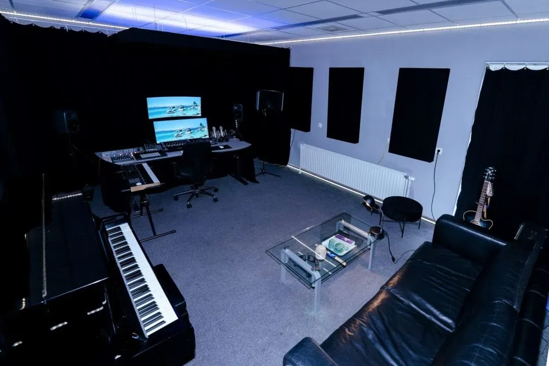 Opnameruimte van Lab205 met piano, werkplek, zithoek en akoestische wandpanelen