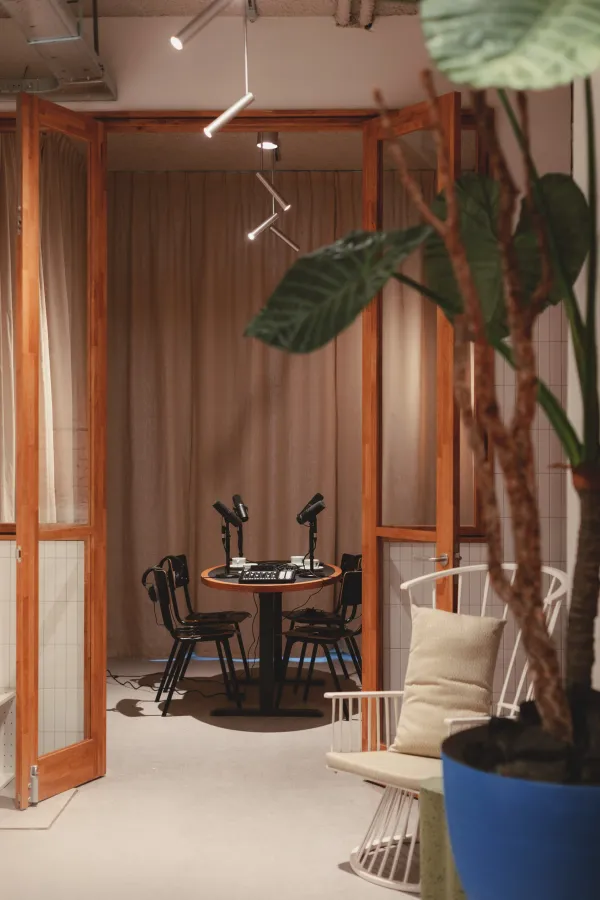 Lege podcastkamer van Man Met Bril met ronde tafel, stoelen en microfoons