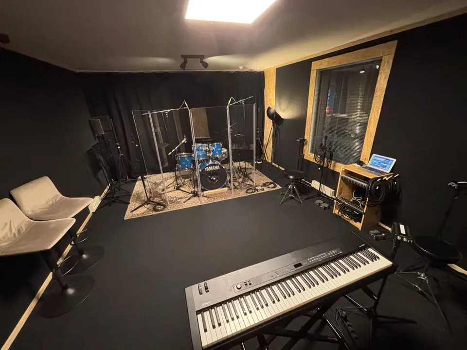 Repetitieruimte van Music Air met drumstel achter schermen, toetseninstrument, microfoons en akoestische wanden