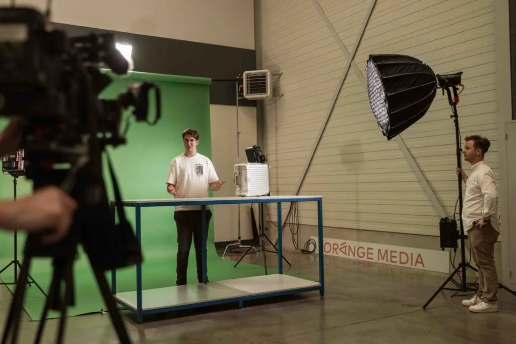 Opnamestudio van Orange Media tijdens een opname, met greenscreen, camera en studioverlichting