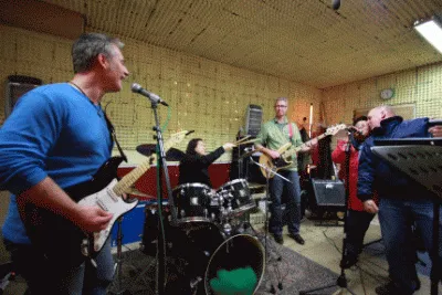 Muzikanten met gitaren en drumstel in een oefenruimte, uit de eigen Spruijt Music Studio-galerij