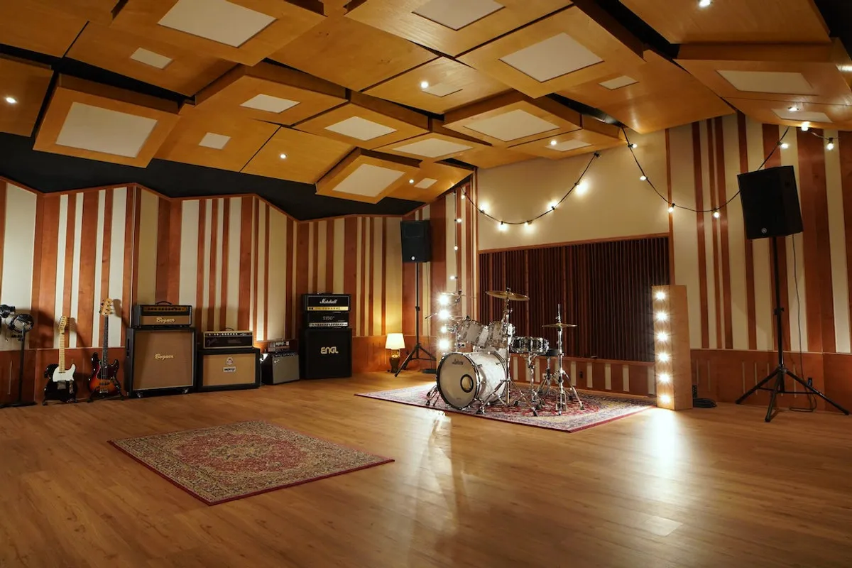 Live room van Independent Recordings met drumstel, versterkers en akoestische panelen