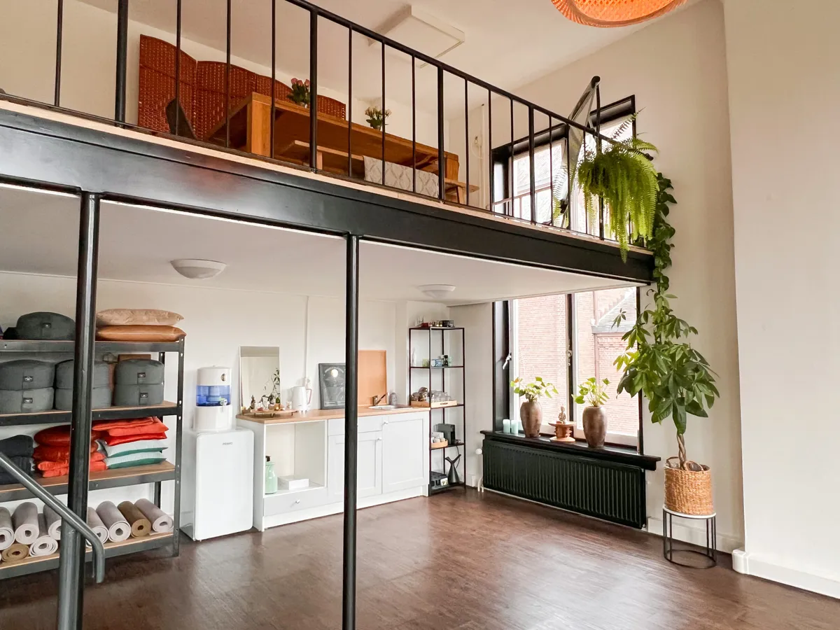 Studio 22 Enkhuizen met vide, hoge ramen, houten vloer, planten en kitchenette
