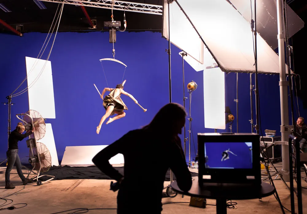 Filmopname bij Schram Film Studios met blauwe achtergrond, verlichting en crew